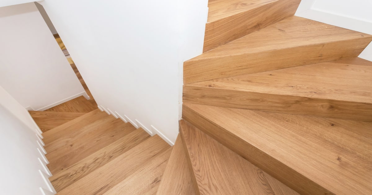 Dit is een houten trappenhal met witte muren.  