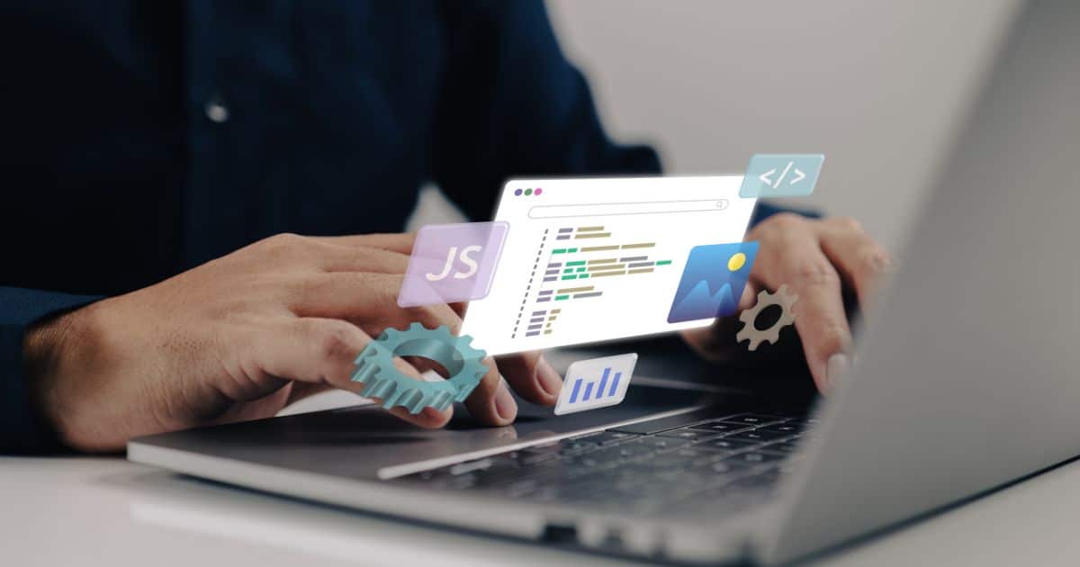 Twee handen van een webdesigner boven het toetsenbord van een laptop. Boven de handen zweven icoontjes van onder meer JavaScript.