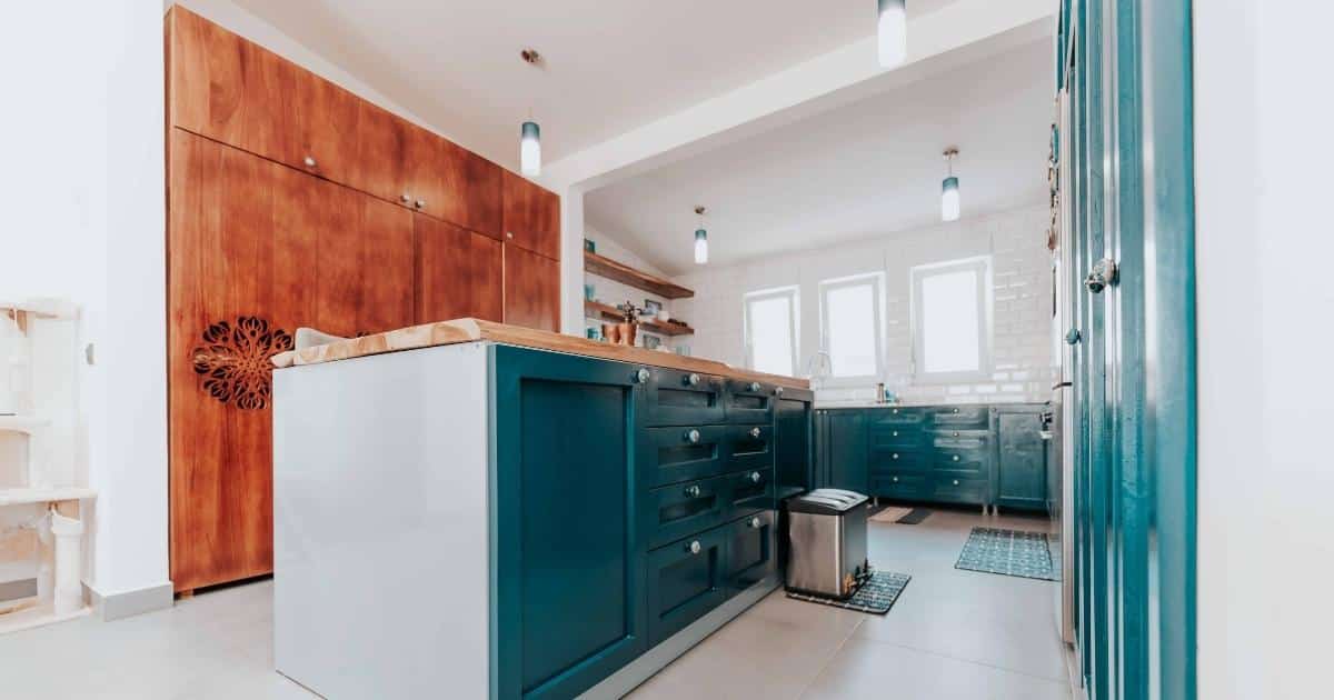 Een moderne keuken met houten kastenwand en blauwe, op maat gemaakte aanrechtblokken.