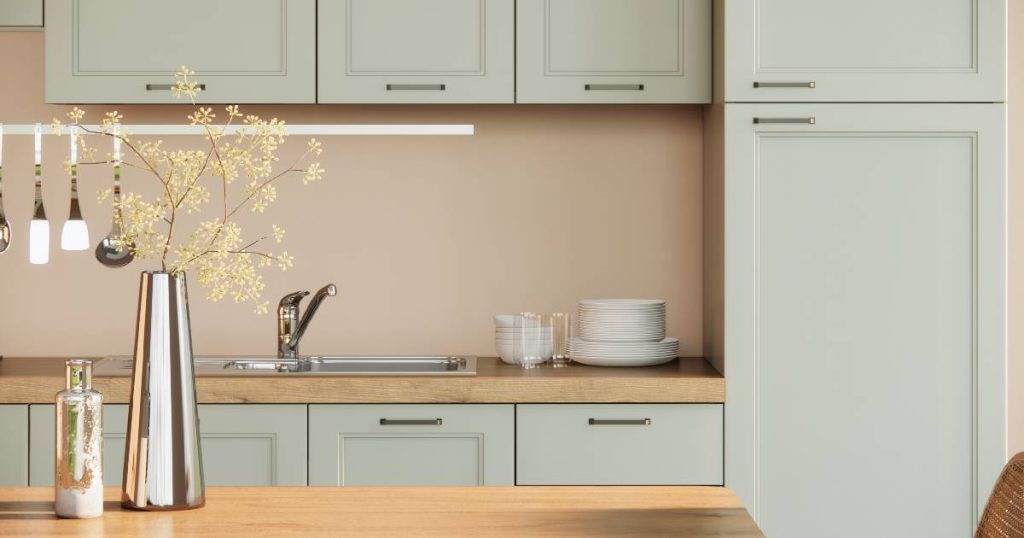 Een keuken na een uitgebreide keukenrenovatie: nette kasten, roze en blauwe pasteltinten en een gezellige inrichting.