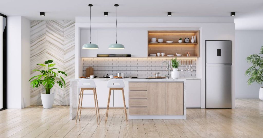 Een gerenoveerde keuken met houten vloer, keukeneiland met bar en zachte paarse pasteltinten.
