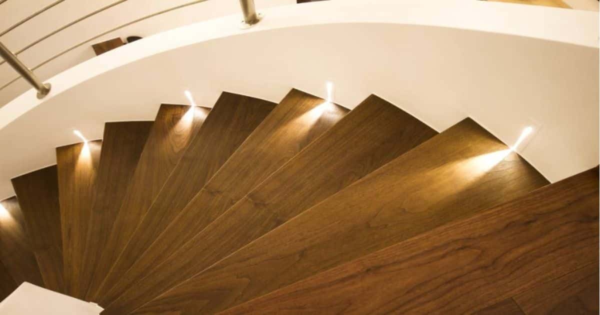 Houten draaitrap met brede treden en ledverlichting langs de zijkant