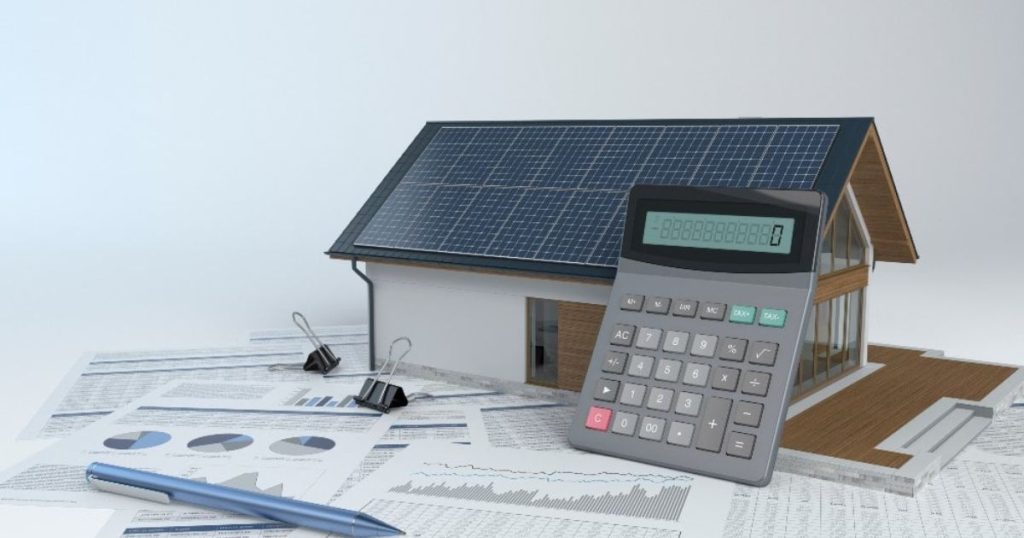 Wat kosten zonnepanelen vandaag? Zonnepanelen op het dak van een huis, een rekentoestel en berekeningen op papier ...
