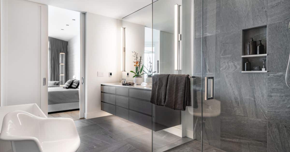 Luxe inloopdouche met donkergrijze tegels en glazen deur in moderne badkamer, inspiratie voor inloopdouche prijs