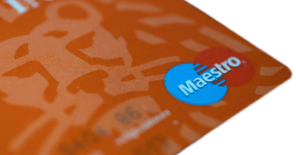 Een oranje Maestro debetkaart, uitgegeven door Mastercard, van ING tegen een witte achtergrond.