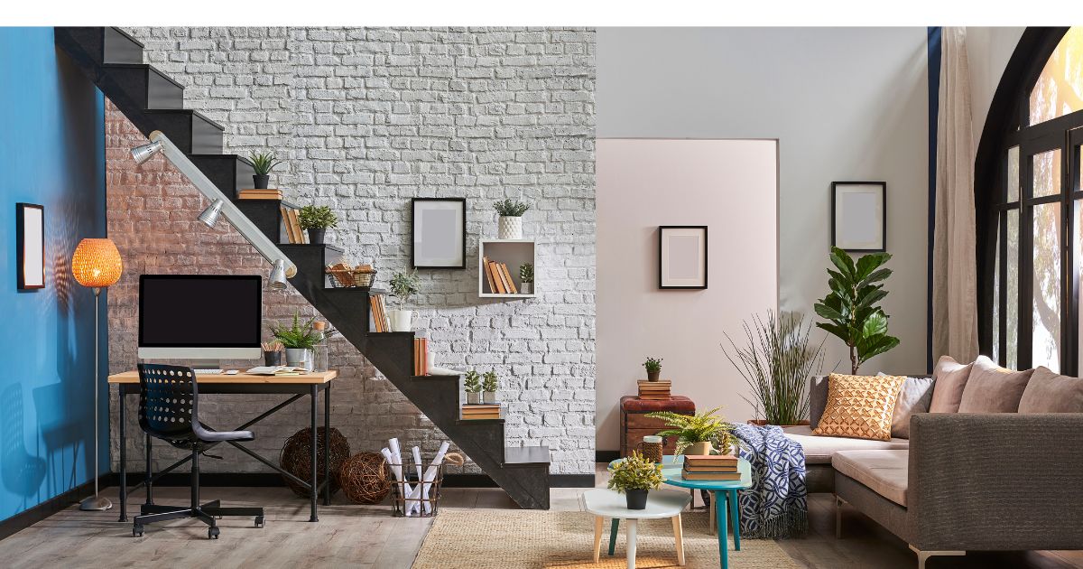 Massief trapontwerp voor industrieel interieur. Op de trap staan planten, net zoals elders in de ruimte om het geheel een zachte, warme uitstraling te geven. Ook opvallend zijn de spots die aan de trap zijn bevestigd voor het bureautje onder de trap.