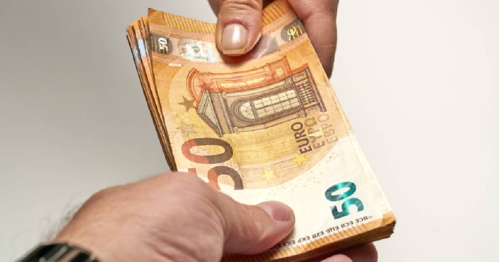 Twee mannen overhandigen elkaar een stapel briefjes van 50 euro. Ze overschrijden het maximum voor een cash betaling niet