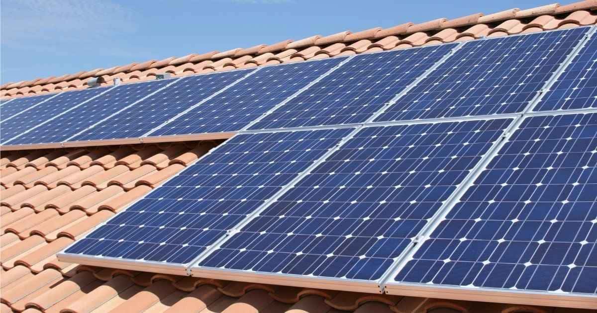 Een oranje pannendak met zonnepanelen op.