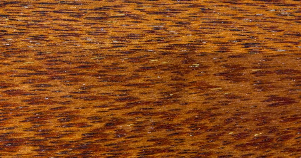 Detail van een merbau parket met duidelijk zichtbare, zwavelgele mergstreepjes.