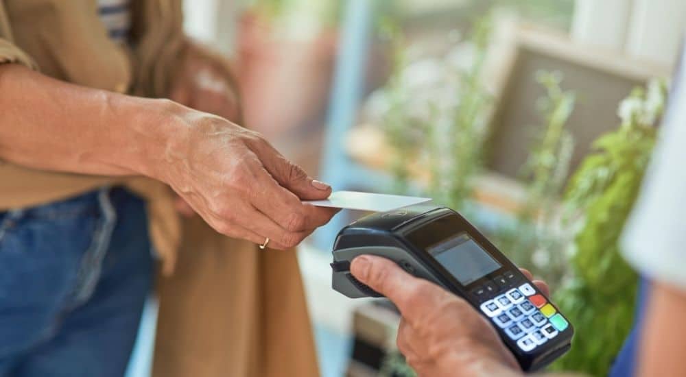 Een dame rekent af met haar bankkaart via een mobiele betaalterminal met ingebouwde printer, zoals verkrijgbaar bij Atos Wordline (overnemer van o.a. Banksys).