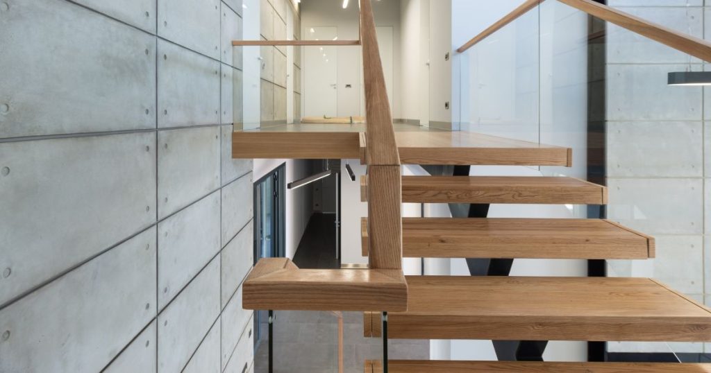 Open moderne trap die een mix van materialen combineert: staal, hout en glas.