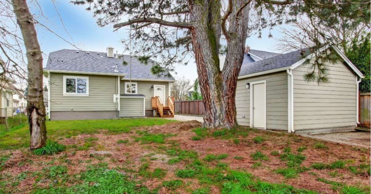 Een moderne woning met houten gevel en uitbouw. De uitbouw werd, net als de kopse zijde van het dak, voorzien van een wolfskap. Naast de woning staat een schuur of tuinhuis met klassiek zadeldak en eenzelfde houten gevel.