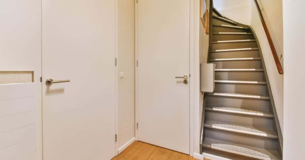 Een molenaarstrap van metaal en hout met 2 deuren in zicht.