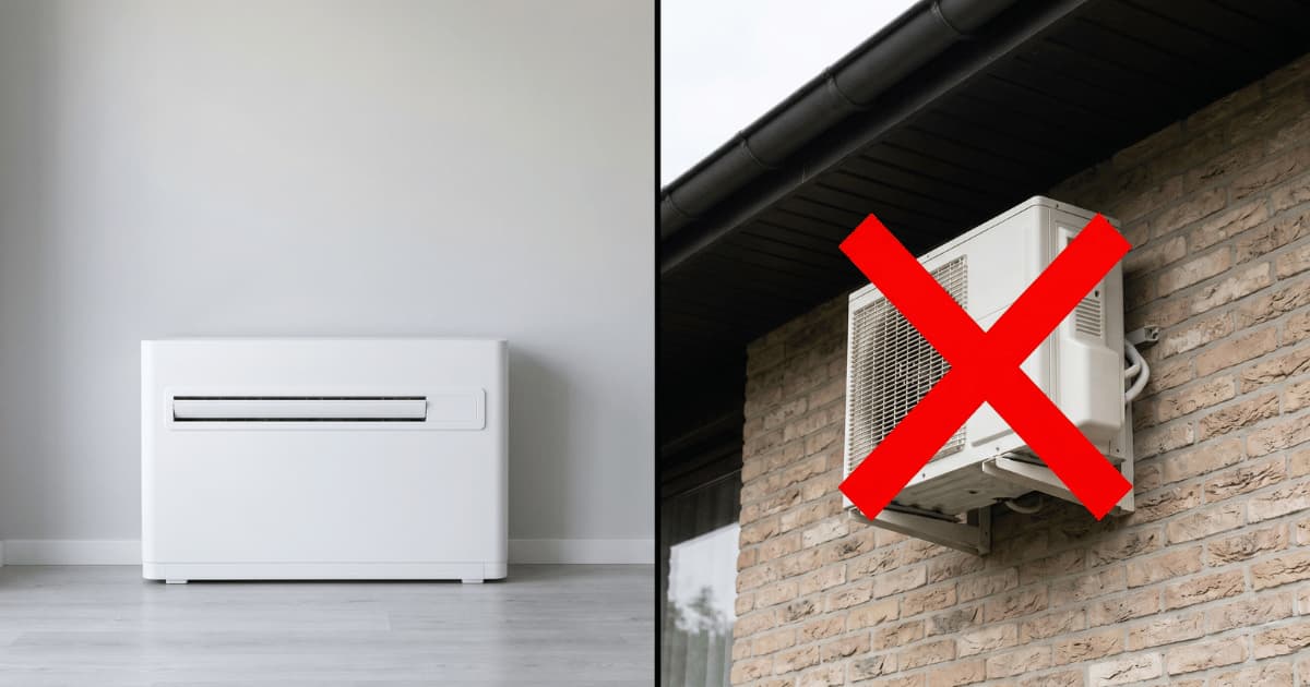 Witte monoblock airco staat laag tegen een lichtgrijze muur op een grijze vloer terwijl rechts een witte buitenunit aan een bakstenen gevel met een groot rood kruis is doorgestreept.