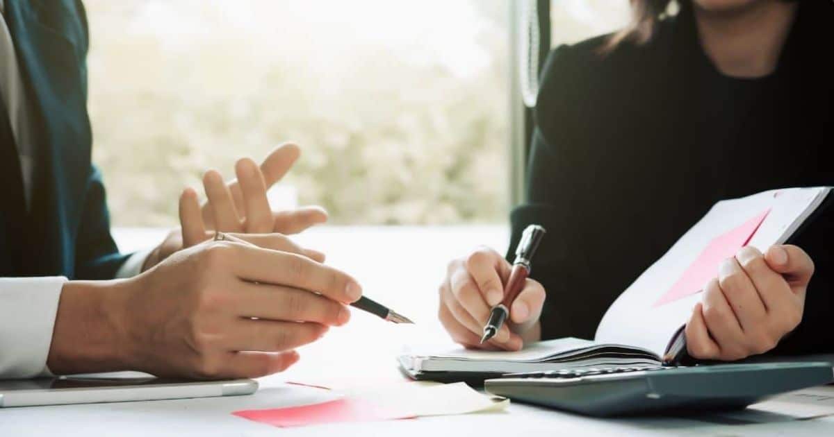 Ondernemer en adviseur bespreken verplichte inschrijving en basisadministratie voor de opstart van een onderneming
