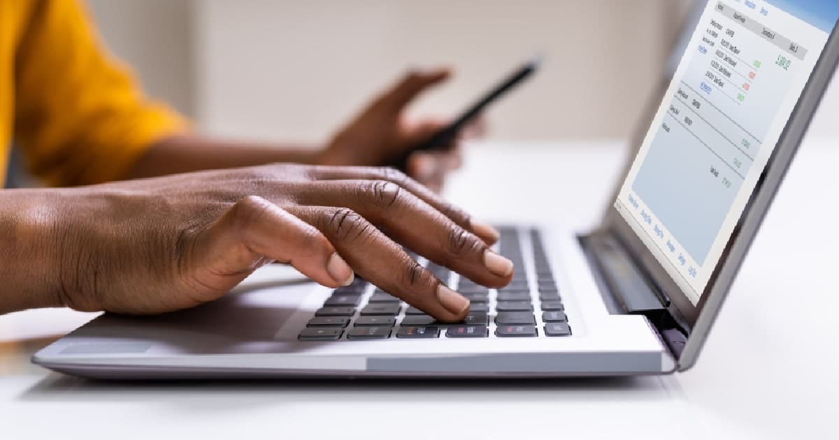 Een vrouwenhand op het toetsenbord van een laptop rondt een online transactie af, beveiligd en verwerkt door Payment Consulting.