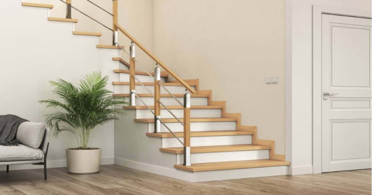 Een lichte houten trap met witte stootborden en een trapleuning met hout- en inoxelementen.