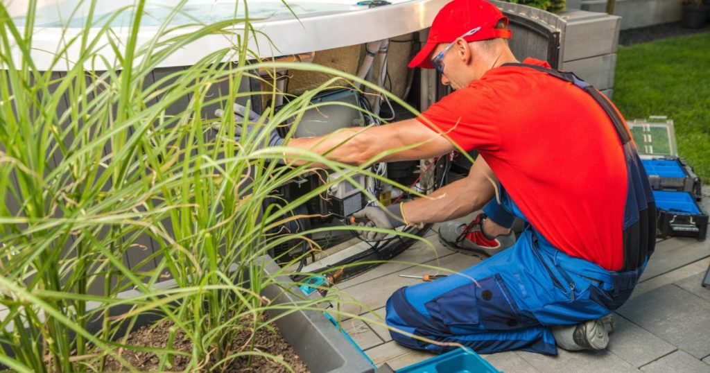 Monteur sluit een warmtepomp aan op een jacuzzi in een groene tuinomgeving voor energiezuinige verwarming.