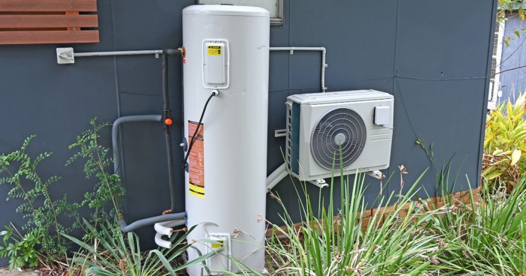 Een geplaatste warmtepompboiler met luchtunit aan de buitenmuur van een huis 