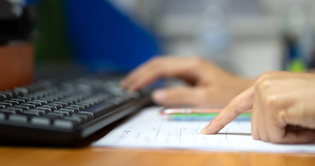 Een dame gebruikt een computer om een premie aan te vragen voor haar dakrenovatie en het isoleren van haar dak.