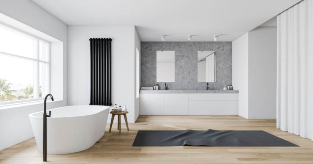 Minimalistische badkamer met vrijstaand bad, zwart kraan, houten vloer, dubbele wastafel en betonnen muur