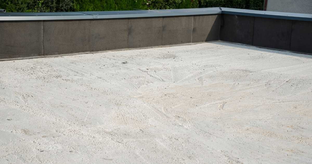 Een plat dak uit grijs gewapend beton met een middelhoge dakrand.