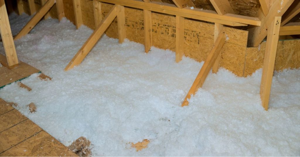 Een zoldervloer van een houten dakconstructie met ingeblazen zoldervloerisolatie.