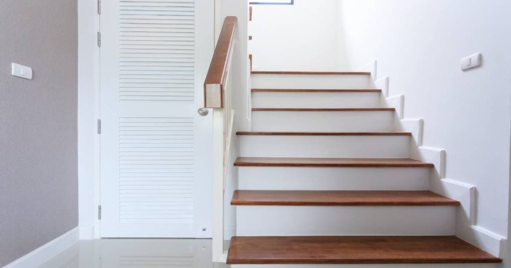 Pvc trap met houtlook traptreden en witte stootborden.