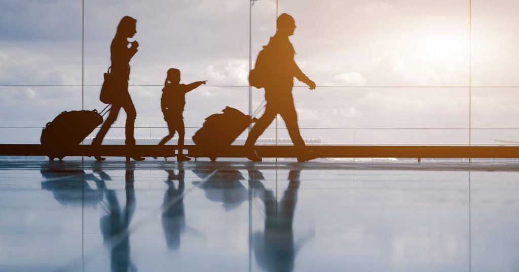 De silhouetten van een moeder, vader en dochter met bagage in een luchthaven, goed verzekerd dankzij hun reisverzekering op maat van het gezin.