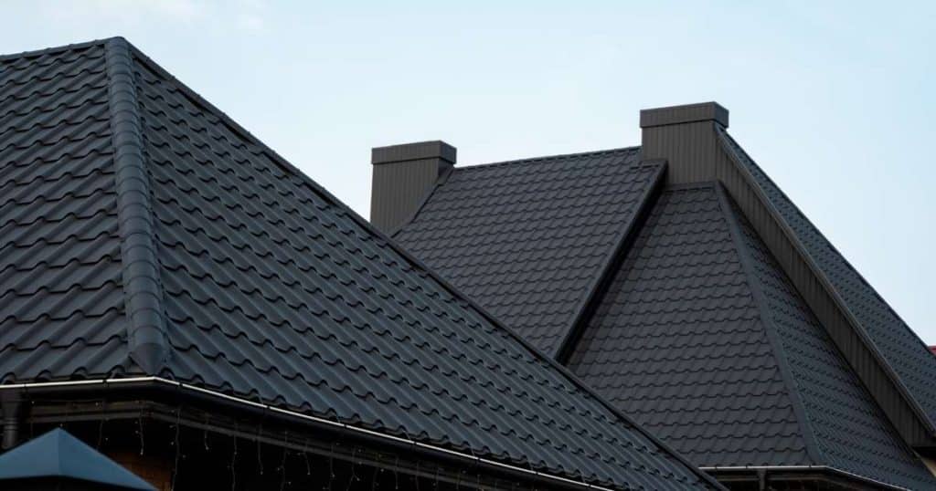 Twee schilddaken naast elkaar. Het dichtstbijzijnde schilddak is minder steil dan het schilddak daarachter. Beide daken zijn afgewerkt met zwarte dakpannen.