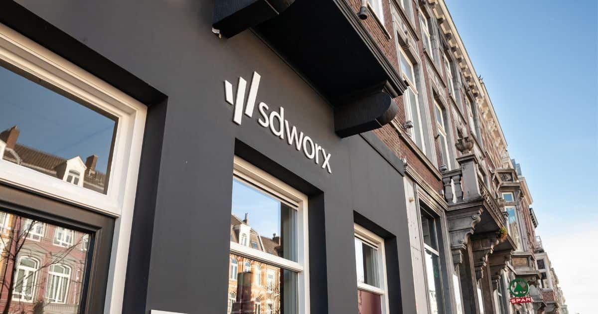 Façade van een SD Worx-kantoor: de gevel van het kantoor zelf oogt modern en strak, daarboven is een meer klassieke voorgevel zichtbaar.