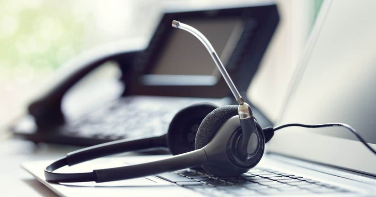 De tools die een call agent nodig heeft: een computer, telefoon en headset met microfoon.