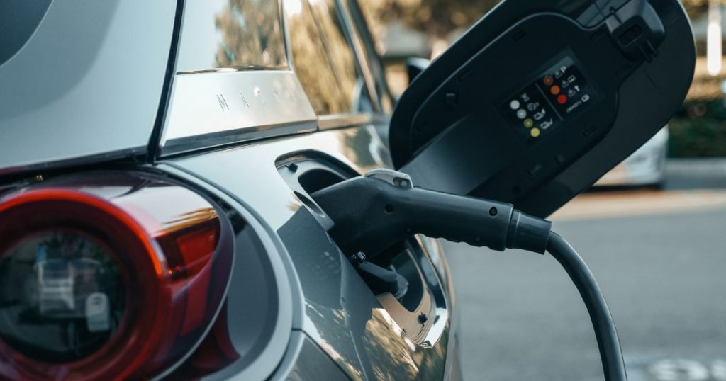Een elektrische auto met een lithium-ion batterij, via een laadkabel aangesloten op een laadpaal.