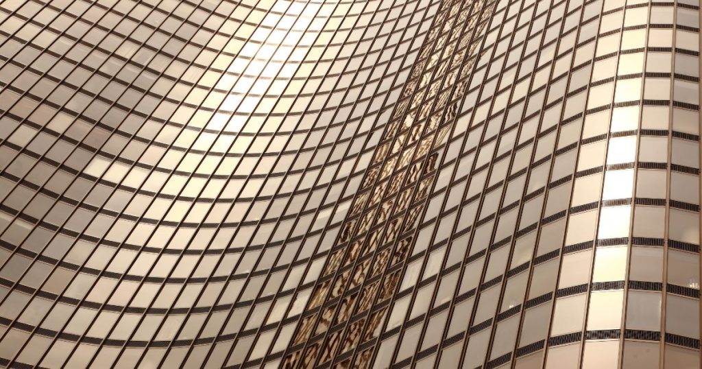 Bronzen spiegelglas voor een kantoorgebouw: de reflectie van de zon op de raampartijen en de golvende structuur van het gebouw geeft het geheel een zachte, golvende gloed.