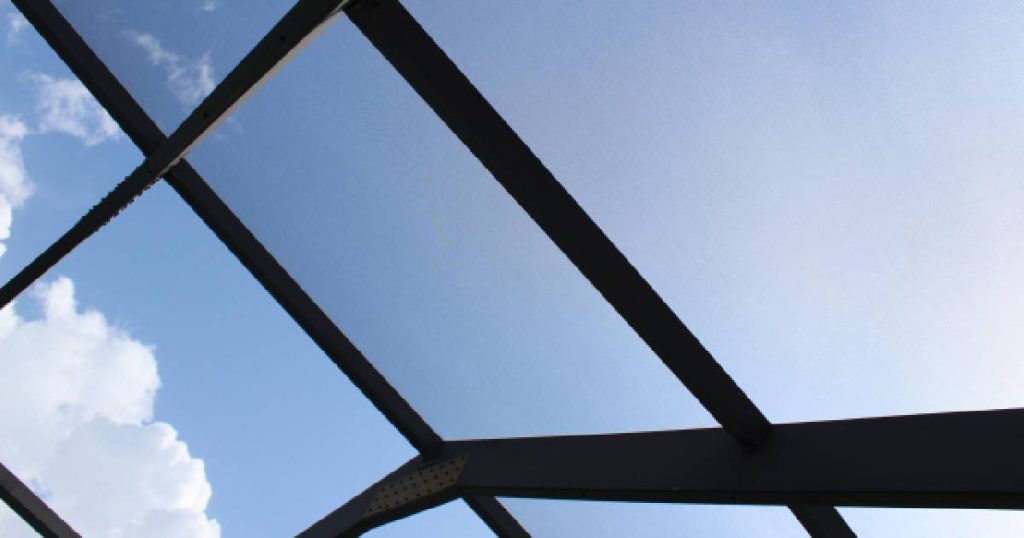 Het dak van een stalen veranda met screens als zonwering.