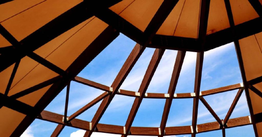 Het dak van een steellook veranda waarin houten elementen verwerkt zijn.