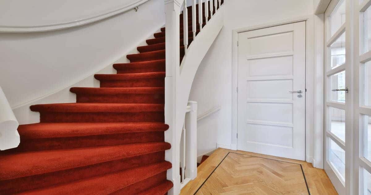 Een trap met rood tapijt als afwerking.