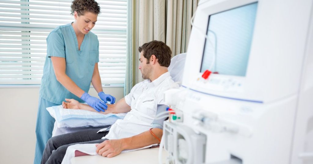 Een verpleegster helpt een patiënt aan de nierdialyse.