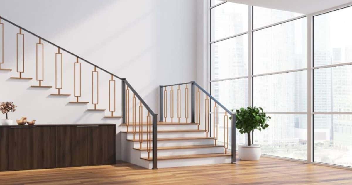 Een trap met onderkwart in moderne woning. Onderaan de trap staat een plant en daarnaast is er een grote witte raam met uitzicht op hoge gebouwen.