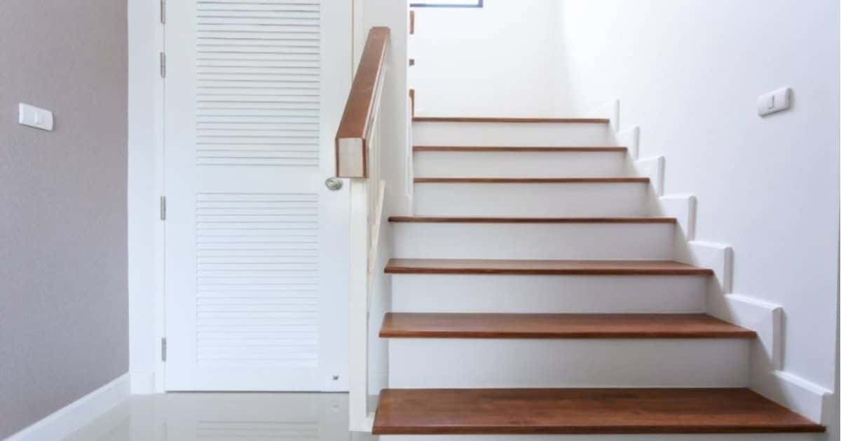 Pvc trap met houtlook traptreden en witte stootborden.