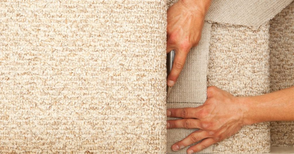 Een vakspecialist plaatst nieuw tapijt op een oude trap: een budgetvriendelijke renovatie met grote impact.