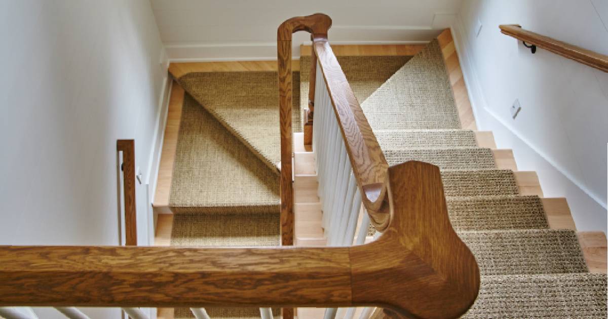 Een houten trappenhuis met een bekleding met tapijt