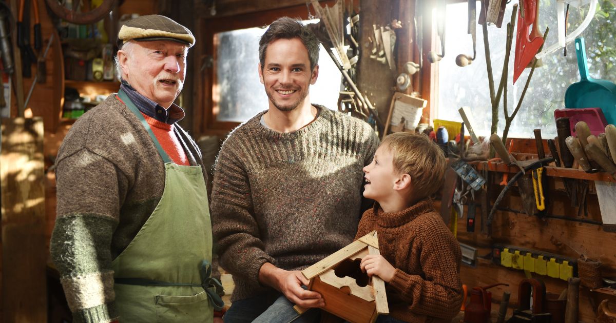 Een grootvader met zijn zoon en kleinkind. Een verzekeringspecialist helpt en begeleidt je met persoonlijk advies en verzekeringsoplossingen op maat van je specifieke situatie en behoeften.
