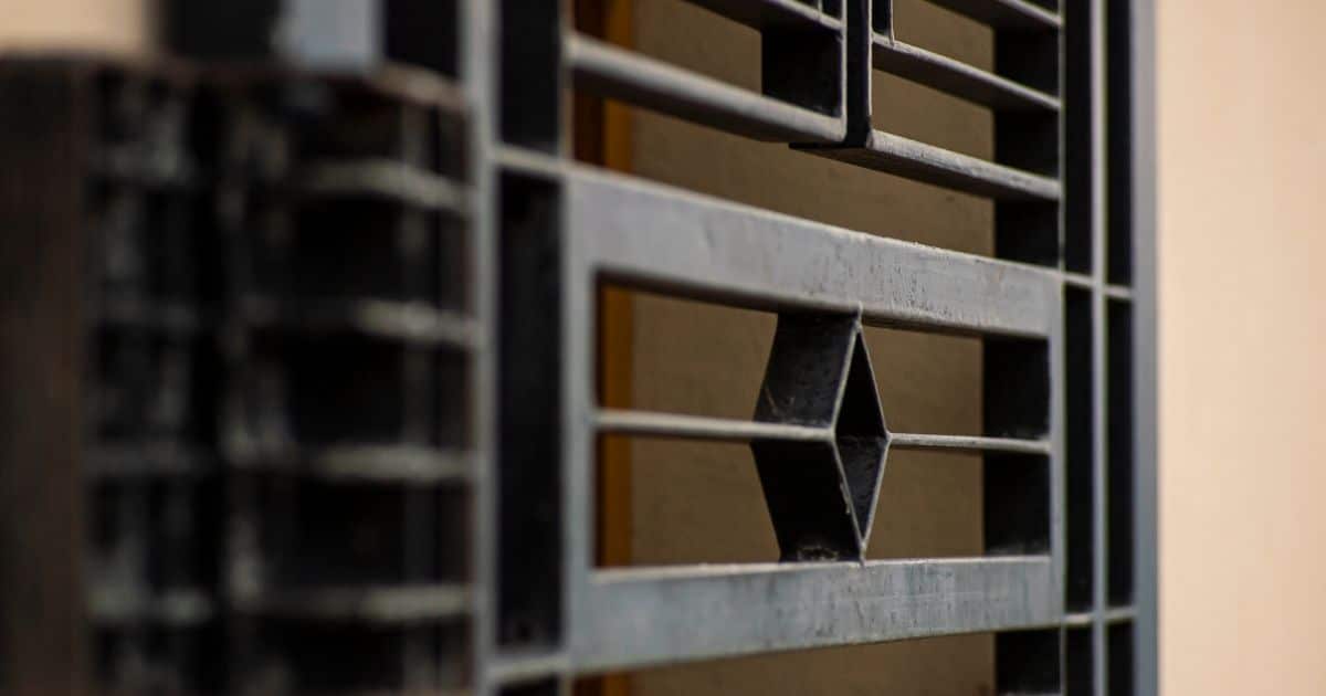 Detail van een veiligheidsdeur in zwart metaal met fraaie maar robuuste afwerking.