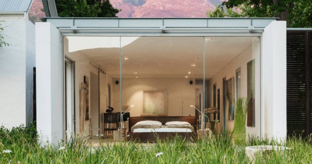 Een ruime veranda met grote vaste glazen kozijnen De veranda wordt gebruikt als slaapkamer.