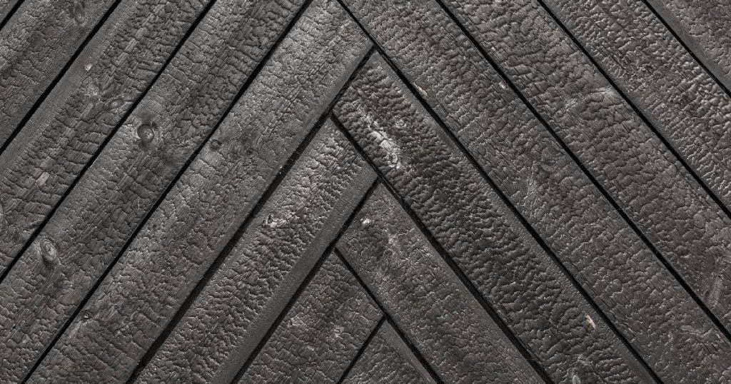 Detail van gebrande houten planken, door hun vocht- en rotbestendige eigenschappen ideaal voor het dichtmaken van een veranda.
