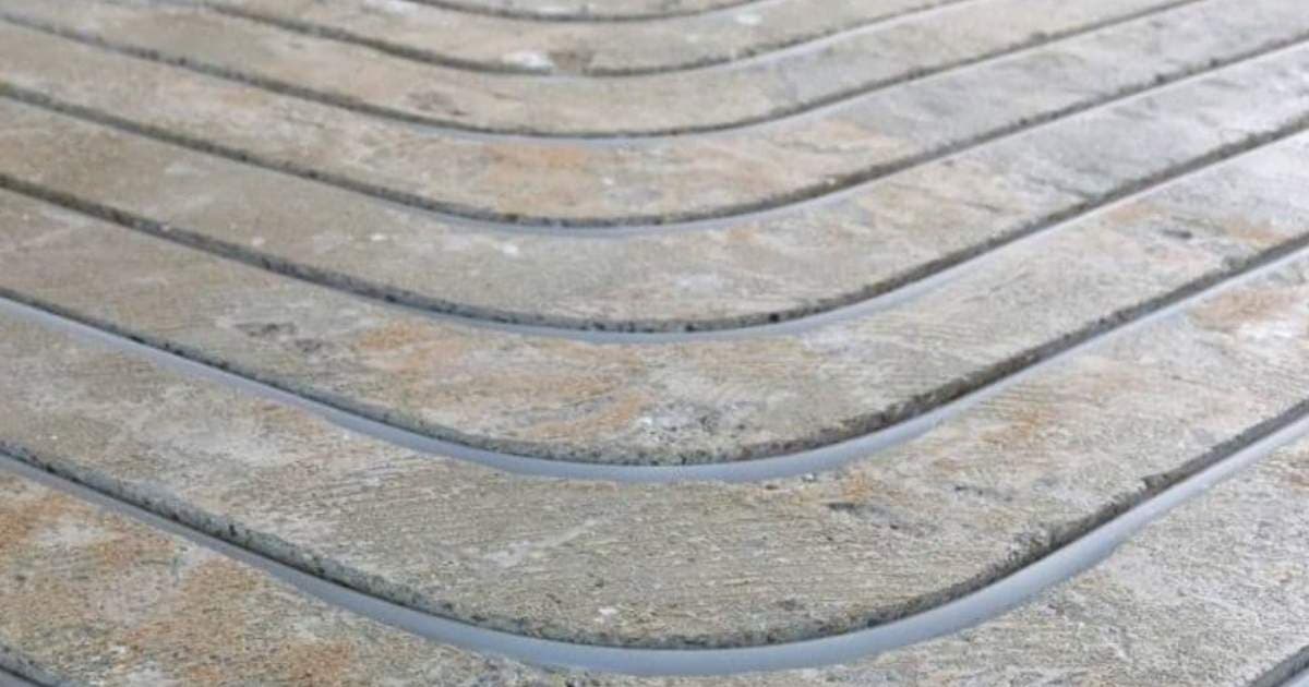 Ingefreesde sleuven in de chape, waarin grijze buizen voor vloerverwarming werden gelegd.