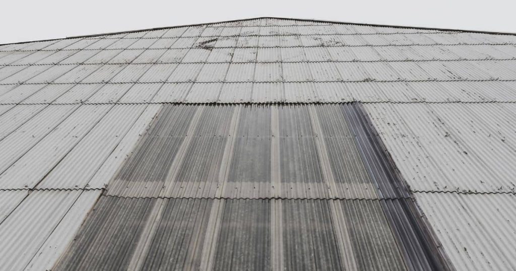 Een wachtgevel van een gebouw met puntdak, afgewerkt met metalen golfplaten.
