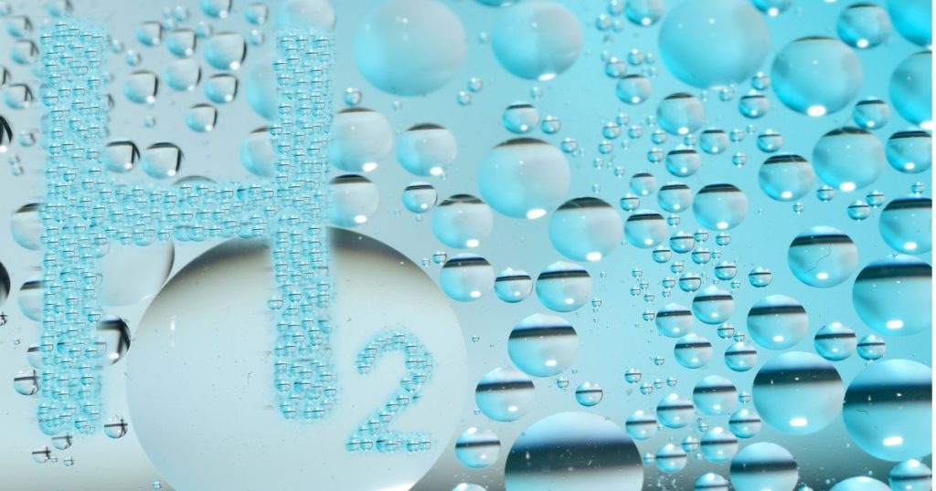 Een hoofdletter 'h' en een '2' gevormd door waterdruppels, een visualisatie van het element waterstof.