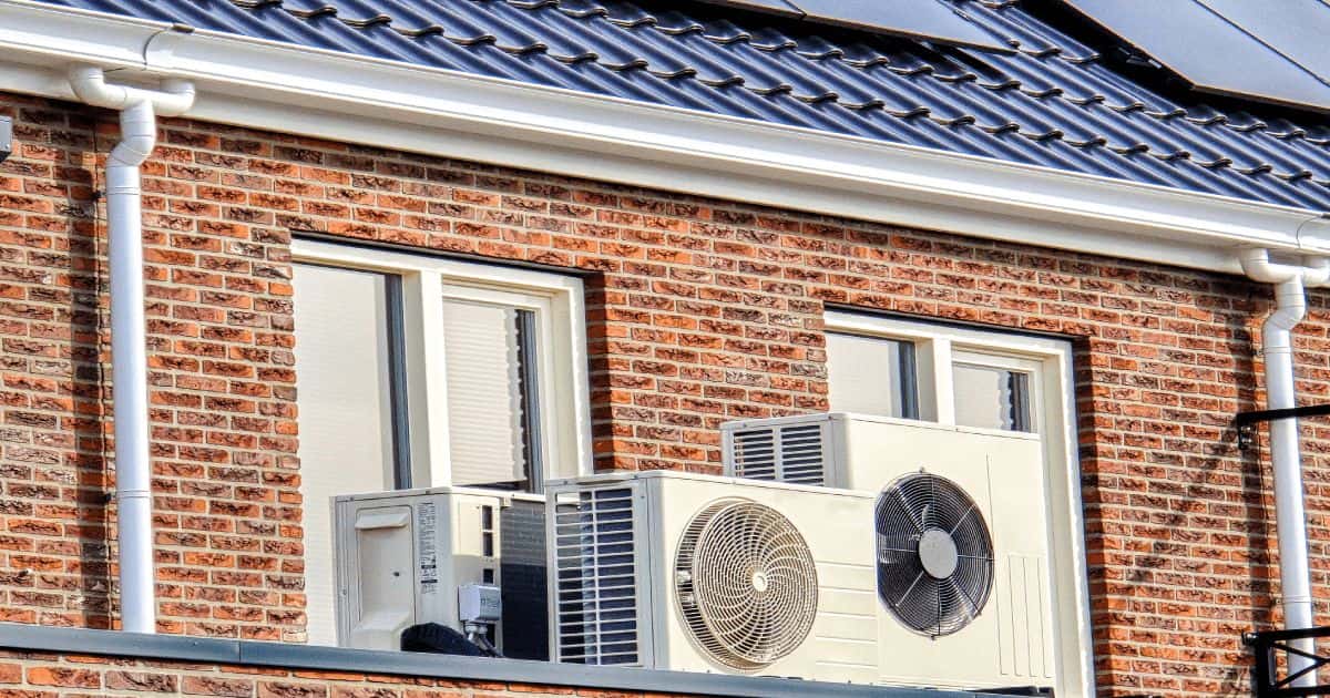 Een woning met twee verschillende split airco's die naast elkaar staan voor twee ramen.